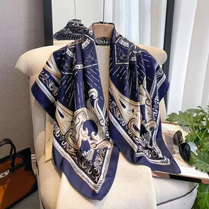 Detailed close-up of a blue silk scarf with baroque patterns draped over a beige chair