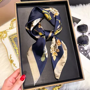 Macro detail of high-quality silk scarf with golden Baroque patterns in a premium gift box