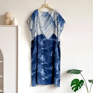 Detail view of the elegant blue and white marbled satin kaftan dress fabric and texture