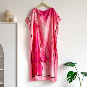 Detailed close-up of pink satin kaftan with abstract marble print and magenta patterns