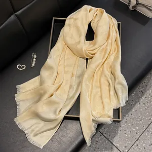 Pañuelo largo de seda champán con textura de jacquard y bordes deshilachados
