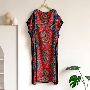 Detail view of red ethnic Kaftan dress with geometric diamond print and black piping edge