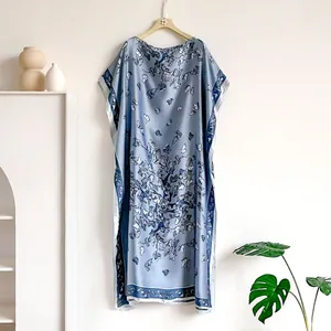 Detailed view of light blue satin kaftan dress featuring elegant butterfly and floral prints