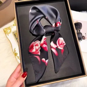 Detail of floral silk twilly scarf with calla lily print in a black gift box