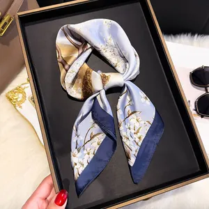 Detail view of a 70cm silk scarf with floral and deer patterns in a premium gift box