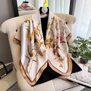 Carré de soie chic de 90 cm avec imprimé floral et logo sur un fauteuil élégant