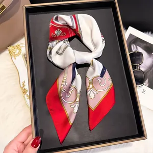Close-up of a printed silk scarf with equestrian patterns in a black gift box