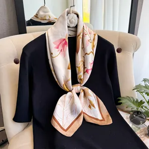 Foulard en soie à imprimé floral rose et bordure marron sur un pull noir