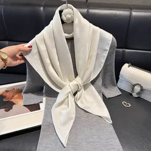 Elegant ivory silk scarf with star jacquard pattern styled on grey knitwear and leather