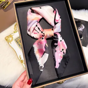 Pink and black silk scarf with abstract butterfly patterns displayed in a luxury gift box