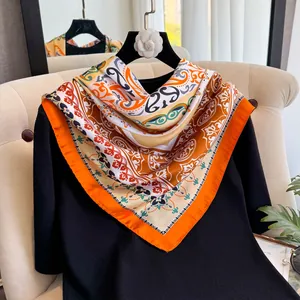 Détail d'un foulard en soie de 90cm avec motifs paisley orange et camélia blanc