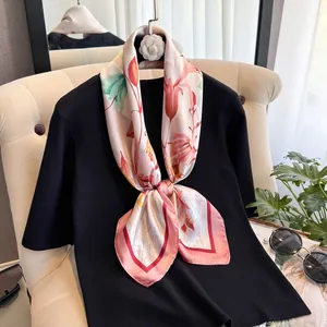 Close-up of floral silk scarf styled on a black top showcasing premium fabric texture
