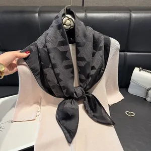 Close-up of black and grey geometric pattern scarf with subtle gold glitter silk texture