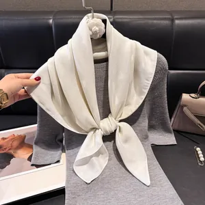 Elegante sciarpa in cotone e lino bianco crema drappeggiata su un maglione a maglia
