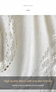 Gros plan du châle en tricot blanc montrant la texture dentelle ajourée et le tissu doux