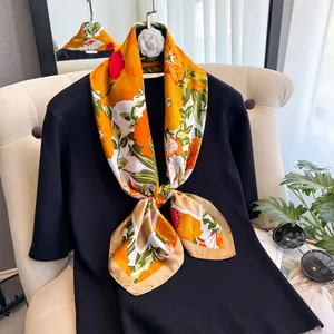 Vue détaillée d'un grand foulard en soie à imprimé floral drapé sur un haut en tricot noir