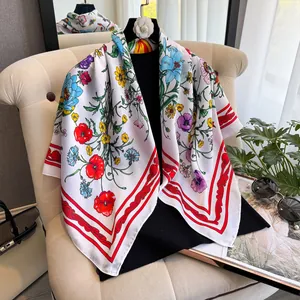 Détail d'un foulard imitation soie de 90cm avec motifs floraux et bordure rouge