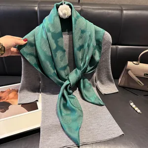 Dettaglio di sciarpa verde smeraldo con cuori dorati su un outfit di tendenza