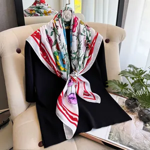 Détail de foulard en soie à fleurs avec bord rouge sur cintre et accessoires de mode
