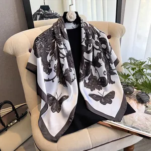 Détail d'un élégant foulard en soie noir et blanc avec motifs baroques et papillons