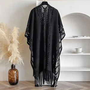 Détail d'un châle au crochet noir avec motifs géométriques bohèmes et de longues franges