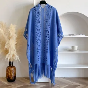 Détail d'un châle bleu ajouré avec motifs en dentelle et longues franges élégantes