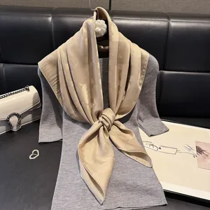 Detail of elegant champagne silk scarf with jacquard pattern on grey dress display