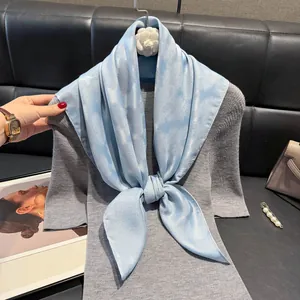 Elegante sciarpa quadrata in cotone e lino azzurro con camelia bianca su maglia grigia