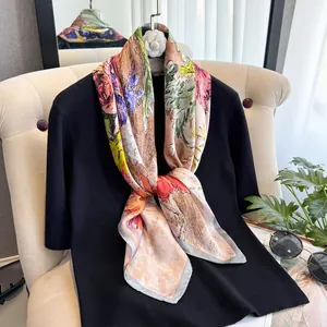 Détail d'un foulard en soie style peinture à l'huile noué sur un haut noir chic