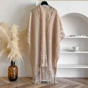 Détail du châle en tricot beige montrant le motif crochet ajouré et les finitions à franges