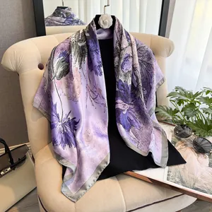 Détail d'un foulard en soie violet de 90cm avec motifs floraux et bords roulés gris