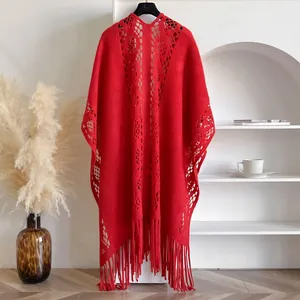 Détail du châle tricoté rouge ajouré avec ourlet à franges et motif géométrique