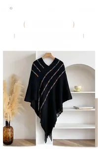 Detail of bohemian knit poncho featuring colorful diagonal stripes and fringe trim