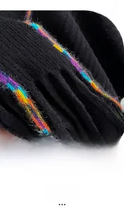 Macro detail of high-quality black knit shawl with vibrant rainbow tassel fringe
