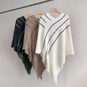 Detailed knit texture and rainbow stripes on women's bohemian tassel ponchos in three colors