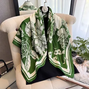 Détail d'un foulard en soie avec motifs floraux blancs sur un fond vert vintage