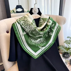 Détail de texture du foulard en soie fleurie verte drapé sur un vêtement noir chic