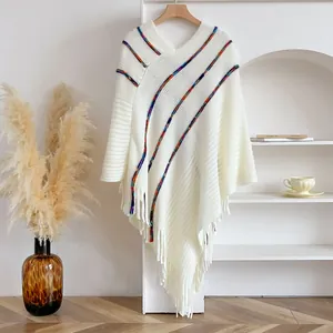 Bohemian oversized knit poncho sweater with colorful stripes and fringe details