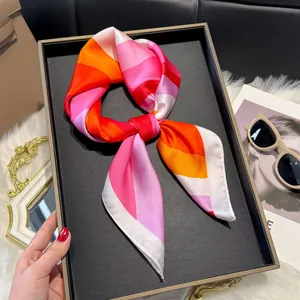 Close-up of vibrant striped satin scarf tied in a bow on a dark display tray