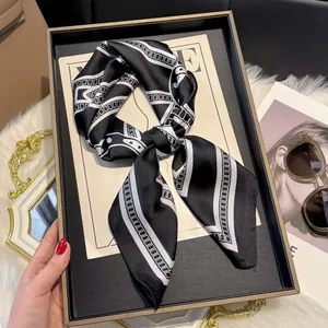 Detail of silk-like scarf with black and white geometric lines styled on a VOGUE magazine