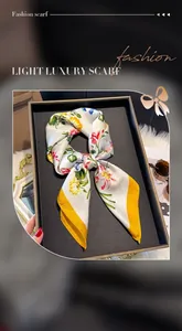 Dettaglio della sciarpa in seta a fiori con bordo giallo in una confezione regalo