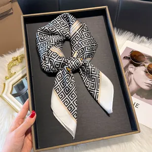 Detailopname van een zijden sjaal met geometrisch patroon op een dienblad met accessoires