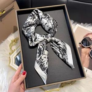 Detail of a silk-like floral scarf tied in a neat knot on a premium display tray