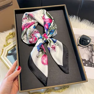 Dettaglio di un elegante foulard in seta con fiori rosa e blu su base bianco avorio