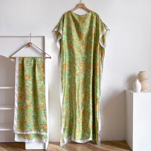 Detailed macro view of the lightweight green satin silk kaftan dress with abstract print