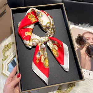 Detailed view of red silk scarf with classic chain and cat patterns in a stylish setting