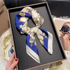 Detailed close-up of a satin square scarf with vintage ballet and jewel patterns on tray