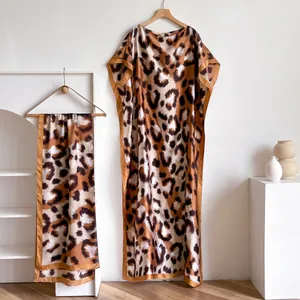 Detail of silk-like leopard print kaftan gown and matching scarf with satin trim