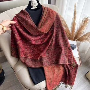Close-up of deep red paisley jacquard shawl with tassel fringe and elegant texture