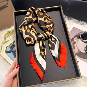 Detail van de zijden sjaaltextuur met luipaardprint en luxe kleurblokken in setting